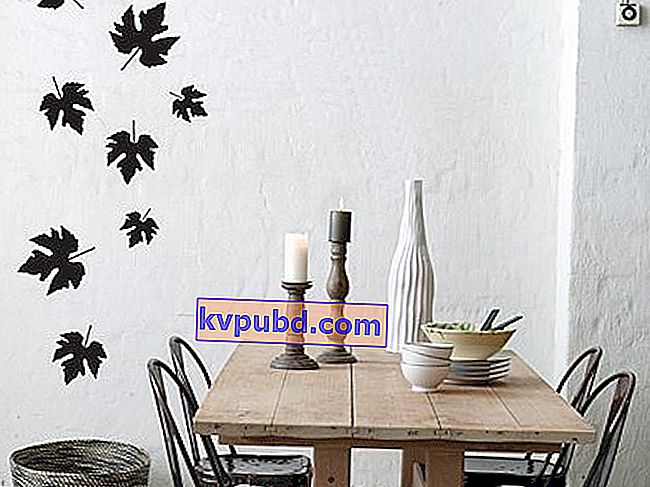 дерев'яний стіл, чорні стільці, чорне листя на стіні, біла ваза