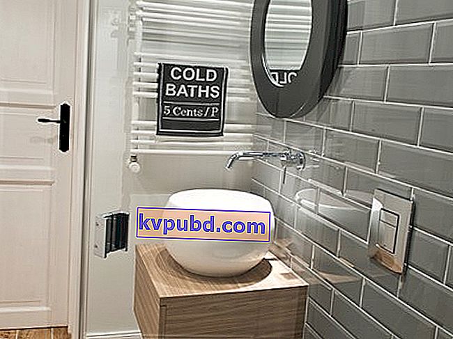 grijze tegels in de badkamer, bolvormige wasbak, ronde badkamerspiegel met zwarte omlijsting
