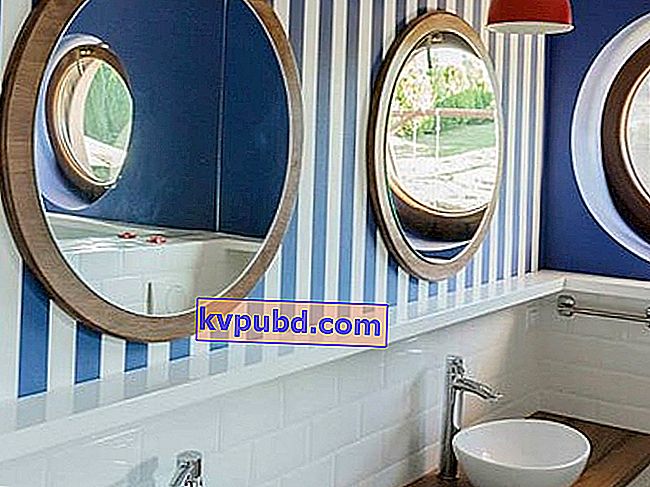 valkoiset ja siniset raidat kylpyhuoneen seinällä, pyöreä peili puurungossa, puinen kylpyhuoneen työtaso